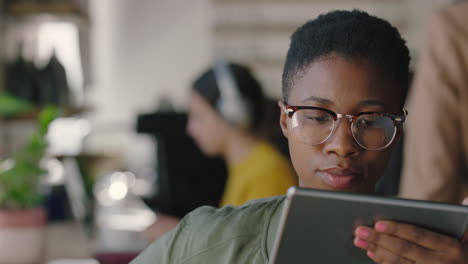 retrato hermosa mujer afroamericana usando una tableta digital en una cafetería bebiendo café navegando en línea leyendo mensajes de redes sociales viendo entretenimiento usando gafas