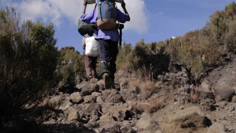 porters carrying gear down trail 1