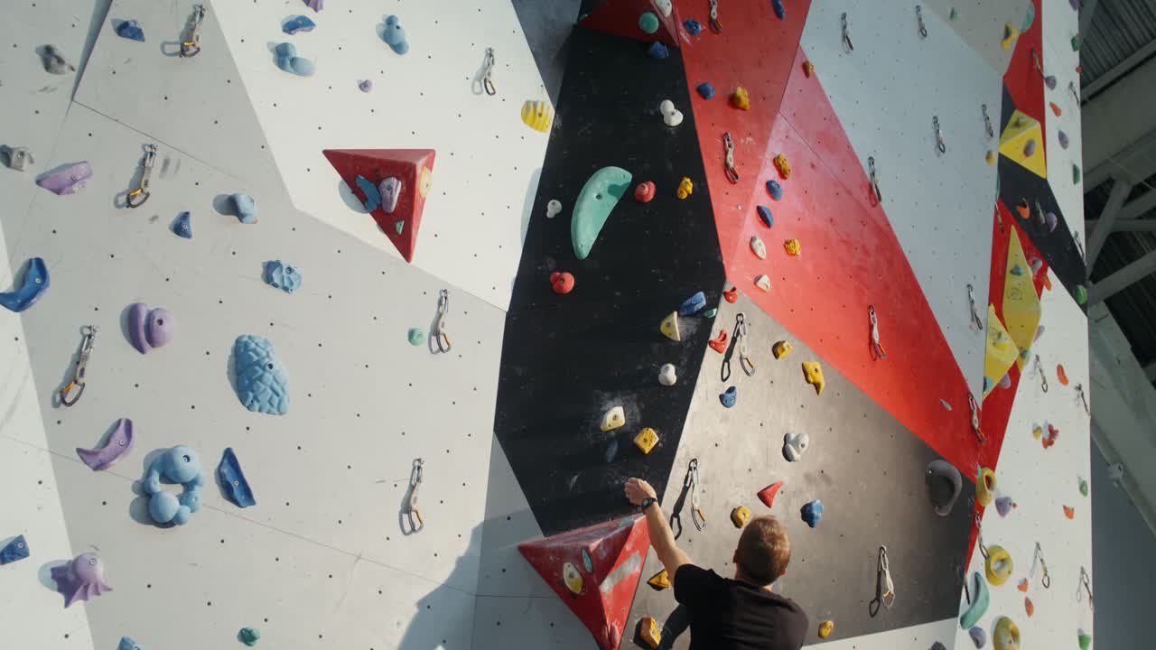 실내 등반 벽 에 바위 등반 하는 사람