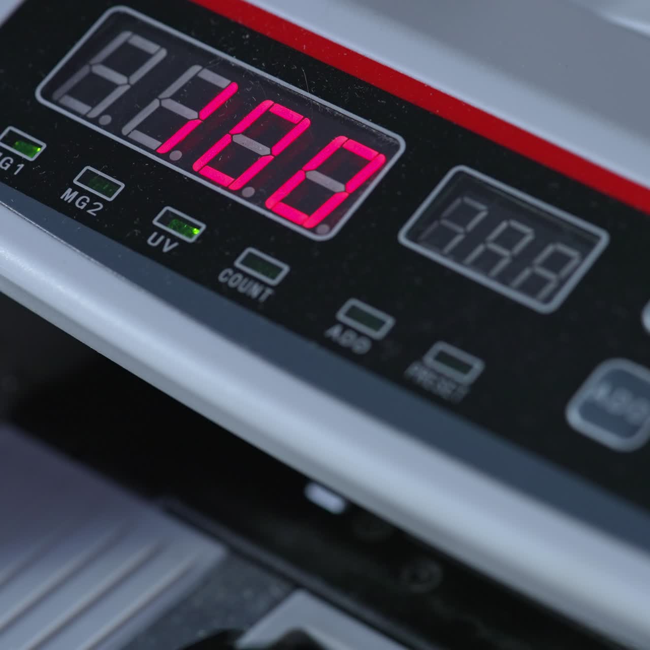 Electronic scoreboard of cash counting machine with numbers on. Dollar bills rotating in the device. Close up