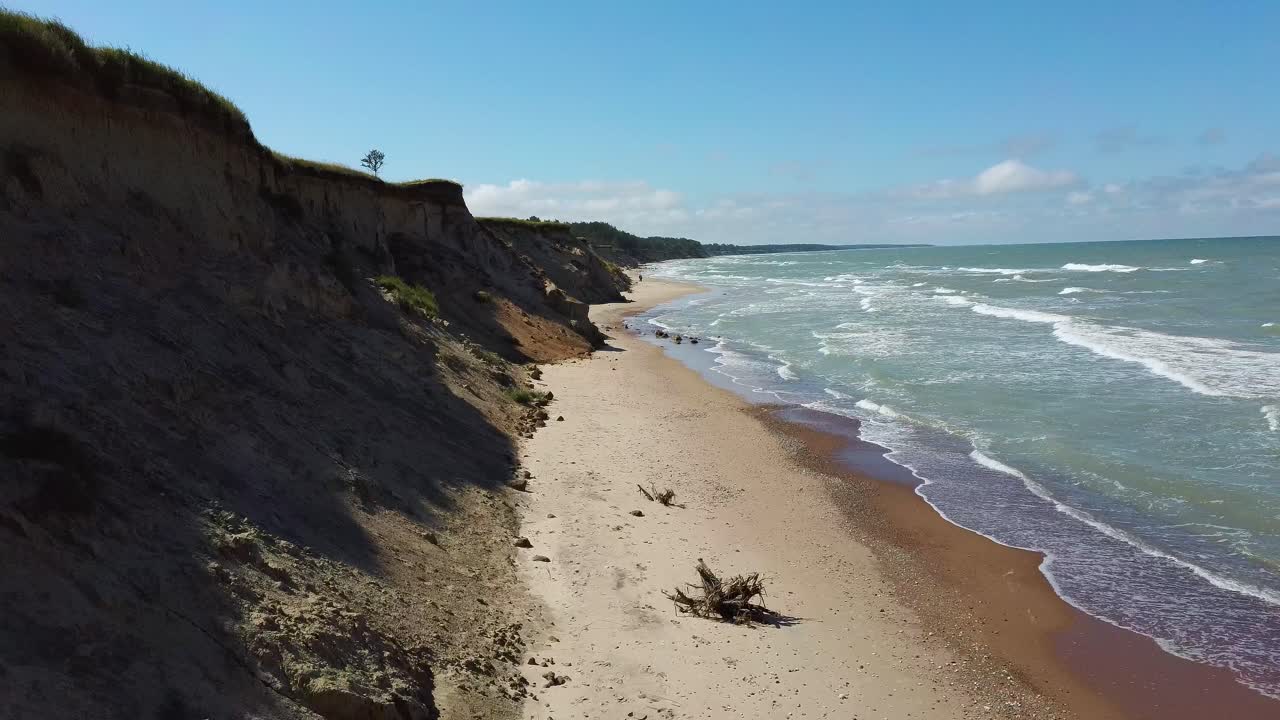 volando sobre la costa del mar báltico ulmale seashore bluffs cerca de pavilosta letonia y deslizamientos de tierra con una cueva ondulada cubierta de rocas y acantilados salpicados