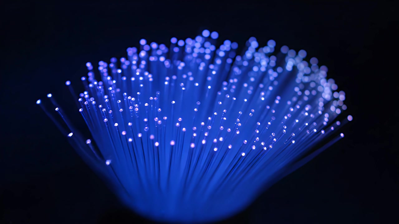 Glowing Blue Fiber Optic Strands in Dark Background
