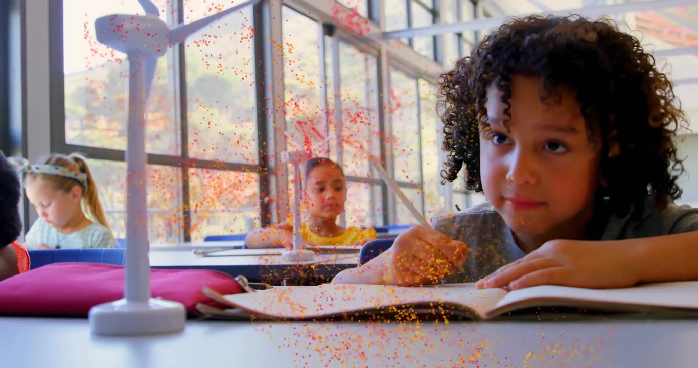 Vertical video: Child writing in class, glitter from window causing page turning and model touching