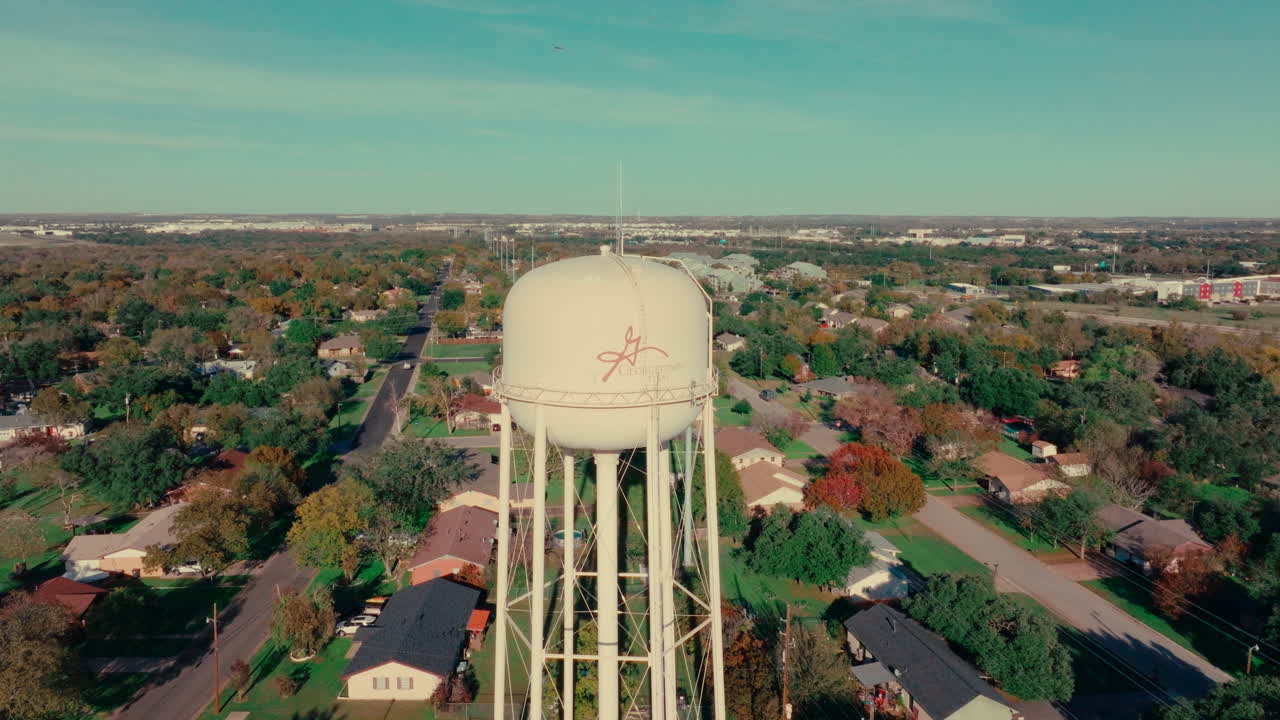 georgetown, texas torre de agua y vecindario en el cielo azul día soleado de otoño, drone aéreo inclinarse hacia abajo en austin, suburbio de texas