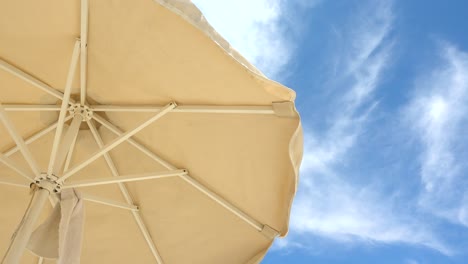 Minimalist-view-with-beach-umbrella-against-beautiful-blue-and-cloudy-sky