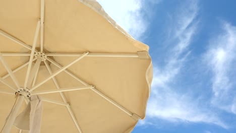vista minimalista con sombrilla de playa contra el hermoso cielo azul y nublado