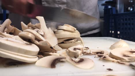 imágenes de primer plano del cocinero cortando champiñones
