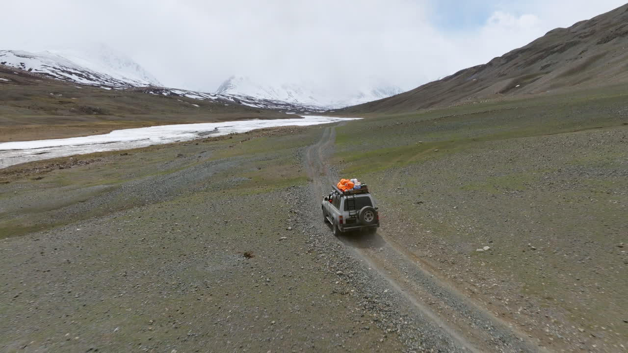 Veicolo che guida fuoristrada attraverso la Valle di Tsagaan Gol nei Monti Altai della Mongolia - Ripresa con drone.