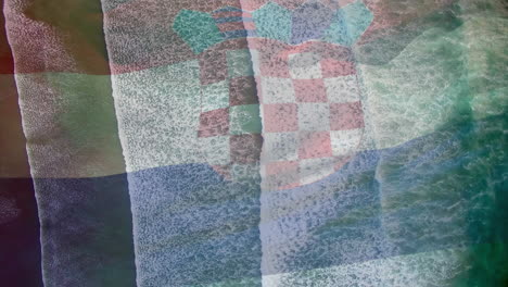 digital composition of waving croatia flag against aerial view of sea waves