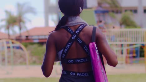 mujer atlética con ropa de paddle caminando de espaldas a la cámara en cámara lenta