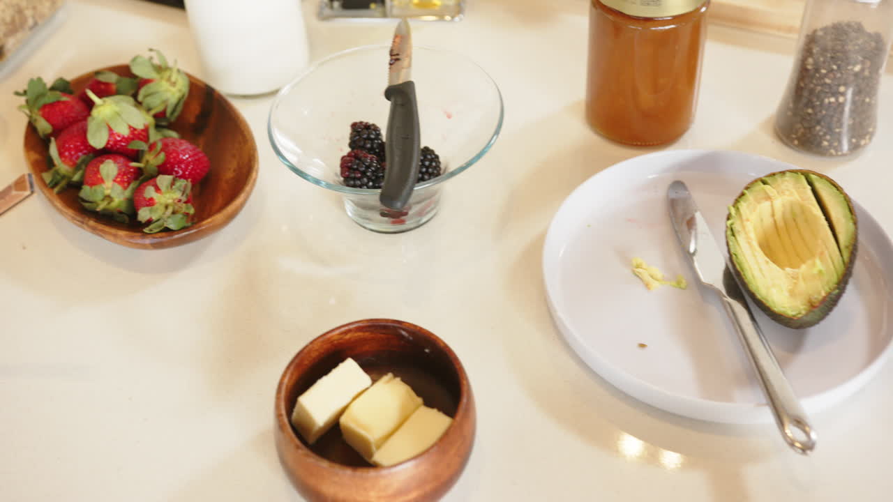 Colazione con fragole fresche, more, avocado e burro sul bancone della cucina, a casa.