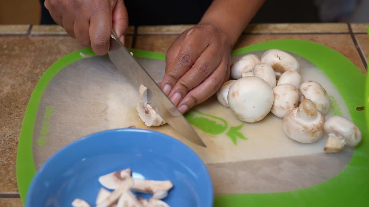 Slicing fresh mushrooms for a homemade, vegetarian recipe - slow motion