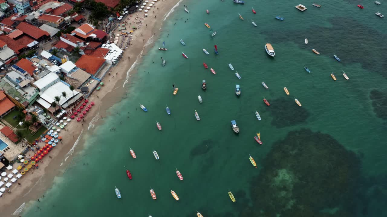ojo de pájaro de arriba hacia abajo drone aéreo plano amplio de la playa de porto de galinhas o puerto de pollo con docenas de veleros anclados y turistas nadando en el agua cristalina del océano en pernambuco, brasil