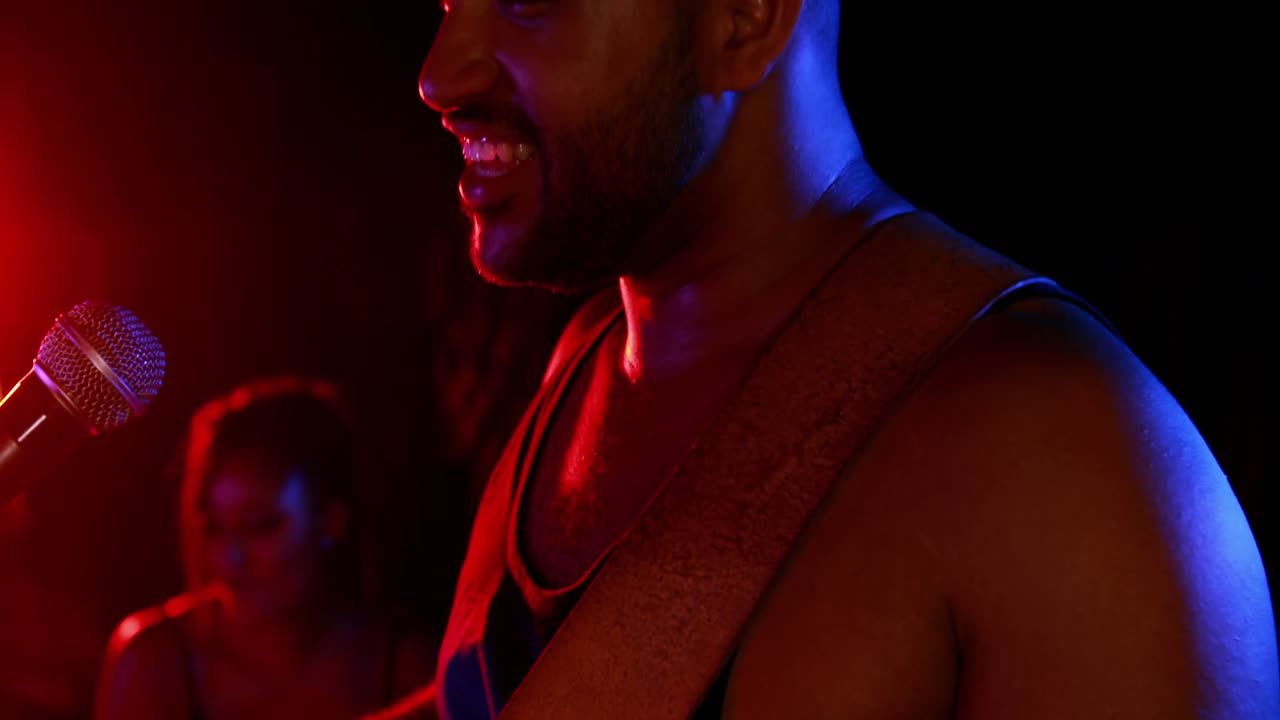 Uomo che canta una canzone mentre suona la chitarra elettrica 4k
