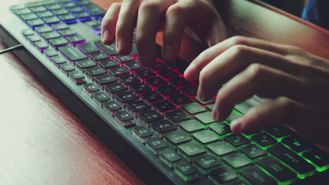 un hombre escribe texto en un teclado retroiluminado 01