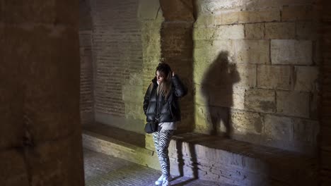 joven solitaria peinándose a mano en un salón medieval de una fortaleza