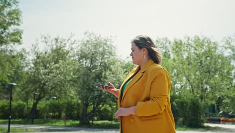 plus-size woman using phone in a park