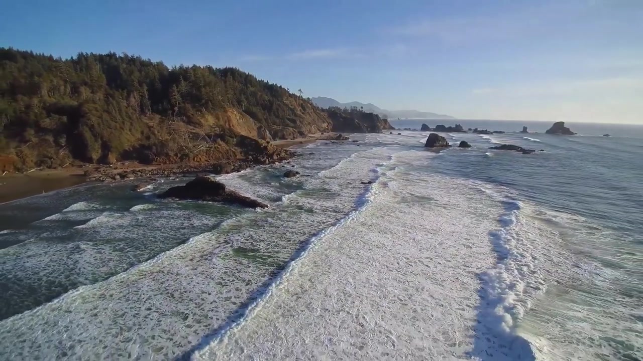 Splendida ripresa aerea in 4K di una spiaggia indiana con onde oceaniche che si infrangono contro rocce frastagliate, mostrando la bellezza naturale, le texture costiere e paesaggi marini cinematografici per acquirenti di filmati stock.