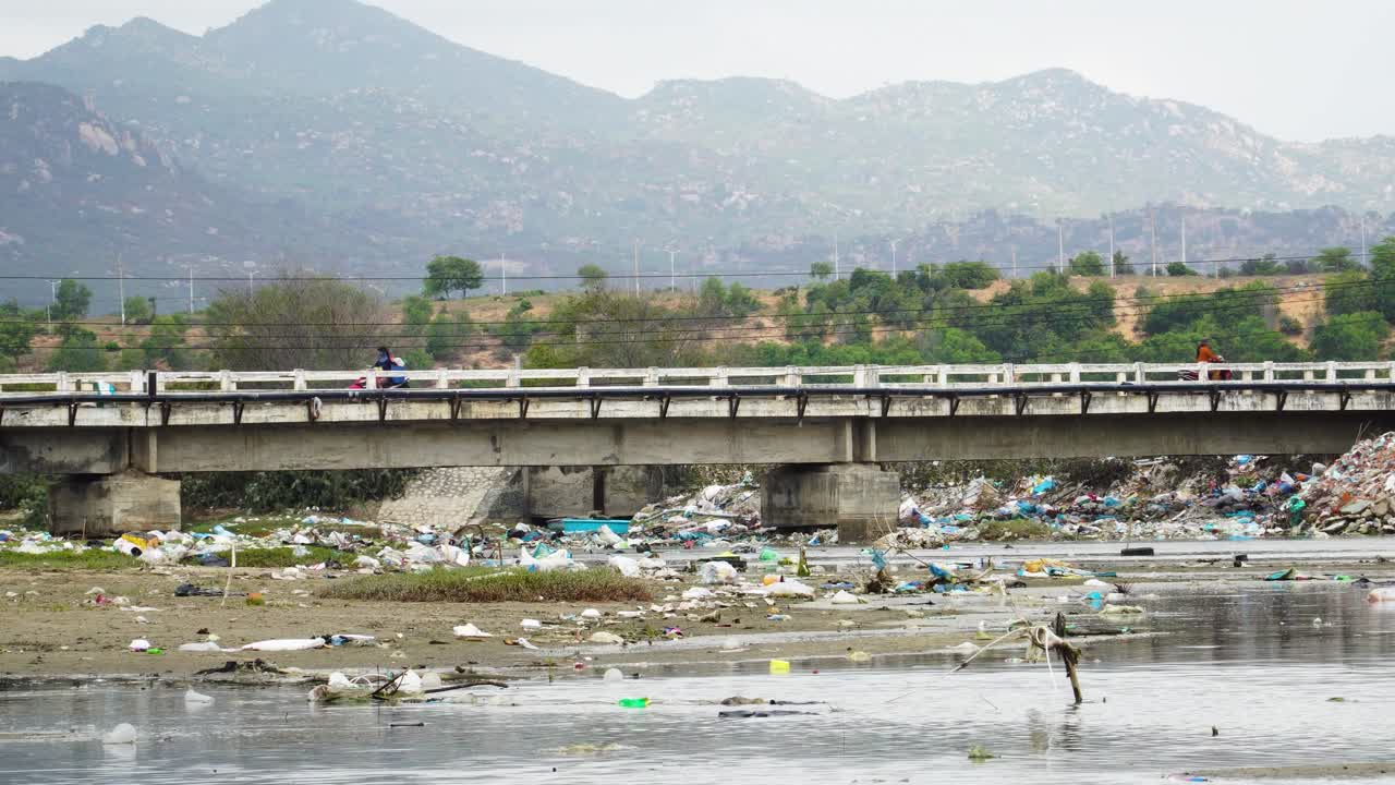 Bridge over river extremely polluted by plastic rubbish in Son Hai, Vietnam