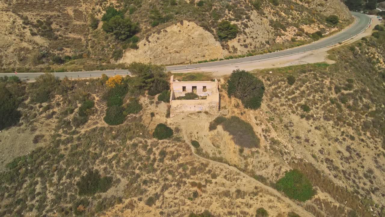 drone moviéndose hacia atrás desde una casa abandonada cerca de la costa rocosa