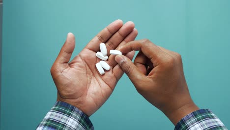 person holding pills in their hand.