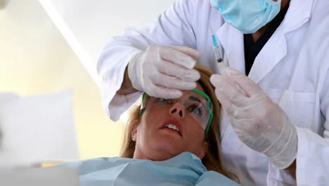 terrified patient looking at needle in dentists chair