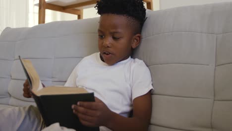 young boy reading at home