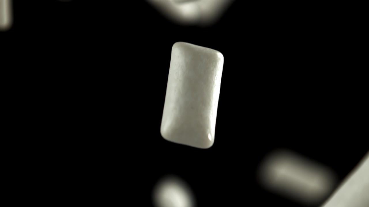 Pezzi di chewing gum bianchi che cadono al rallentatore