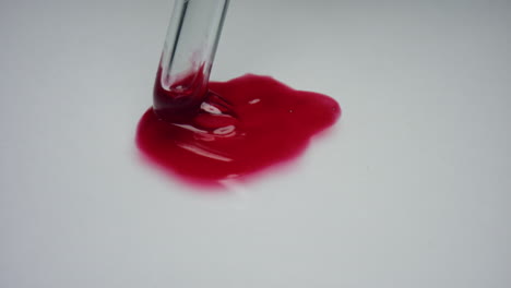 Medical-researcher-stirring-blood-with-pipette.-Blood-drop-on-white-background