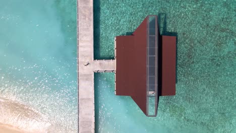 mujer de pie en la casa del barco del muelle de gili meno durante el hermoso día de verano