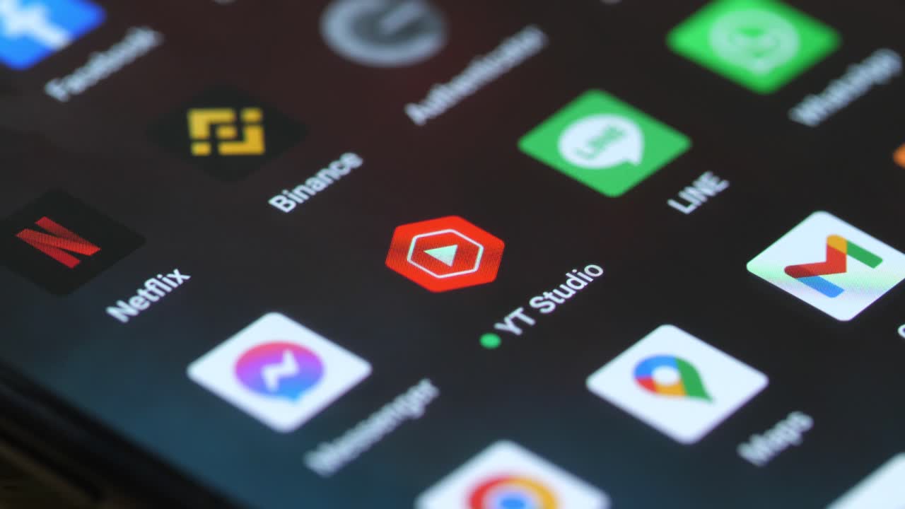 macro tocando con el dedo el icono del estudio yt en el teléfono inteligente