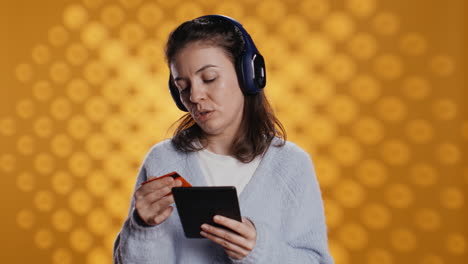 woman reading ebook, listening music, purchasing books, studio background