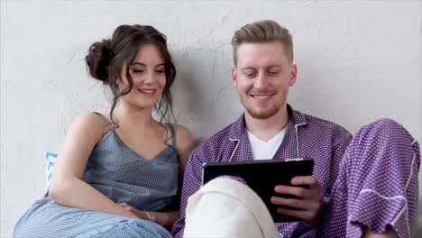 couple watching tablet in bed