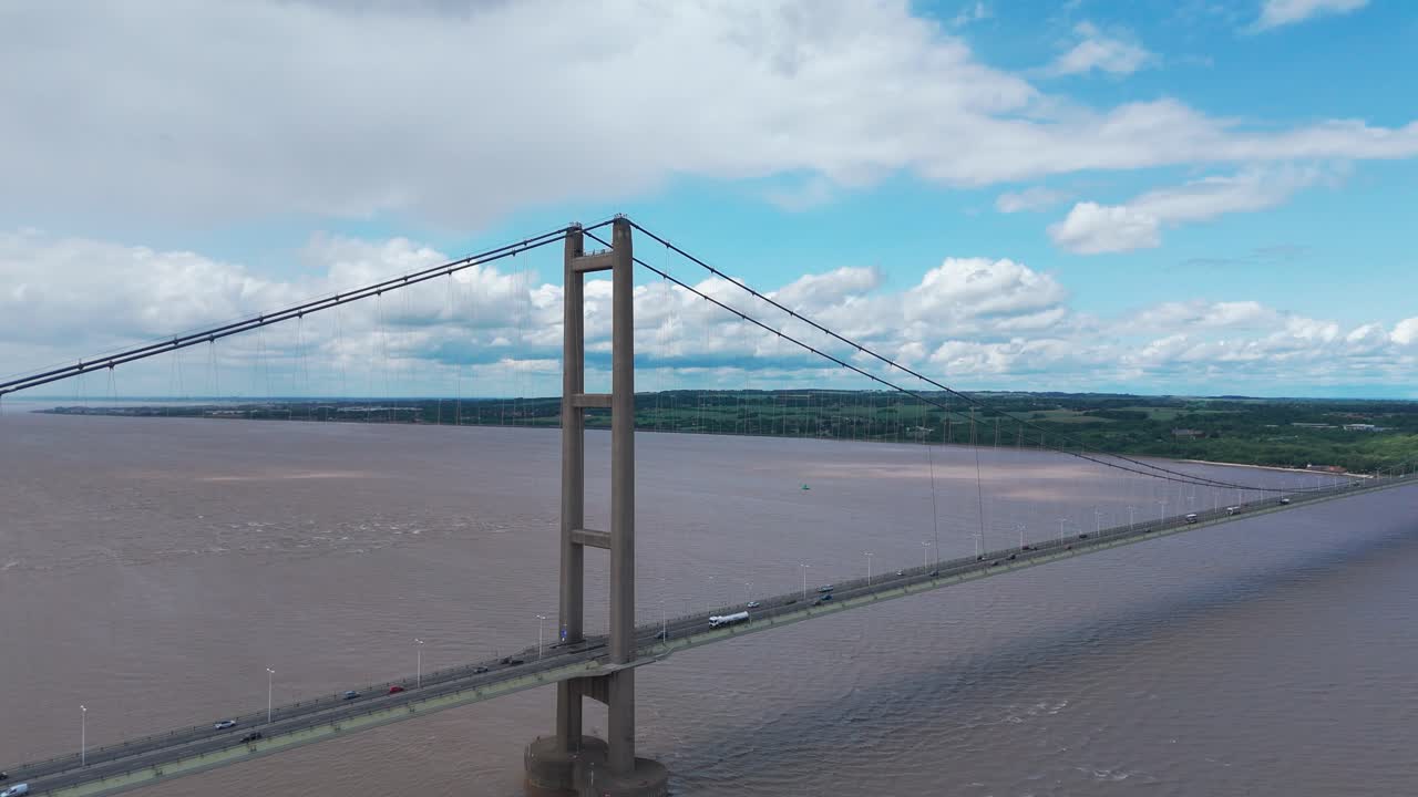 Humber bridge with a dramatic sky and calm waters below, aerial view