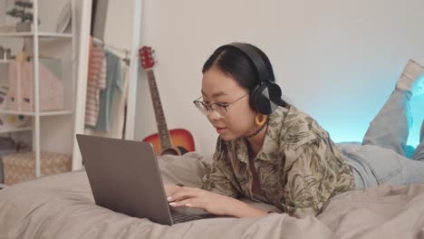 teenage girl texting with friends on laptop