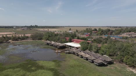 Aerial-flight-to-water-side-rustic-restaurant-in-Prey-Pros,-Cambodia