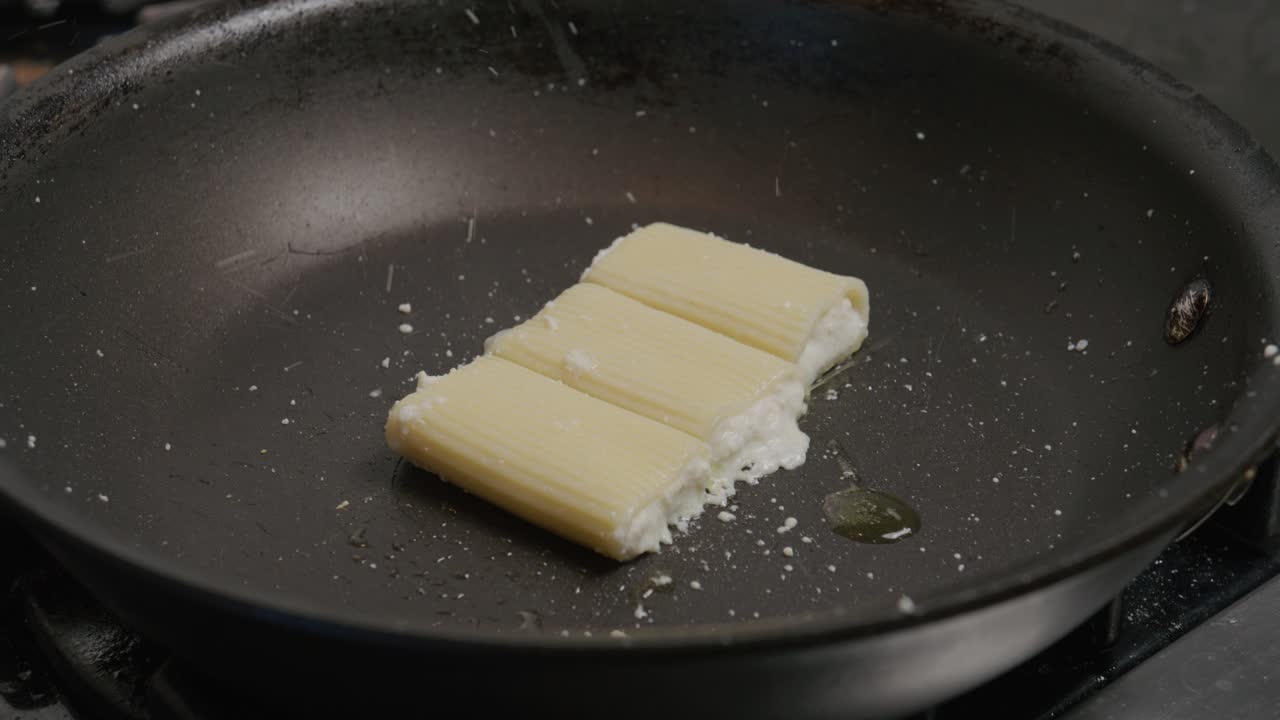 la salsa de pasta cremosa salpica energéticamente en una sartén