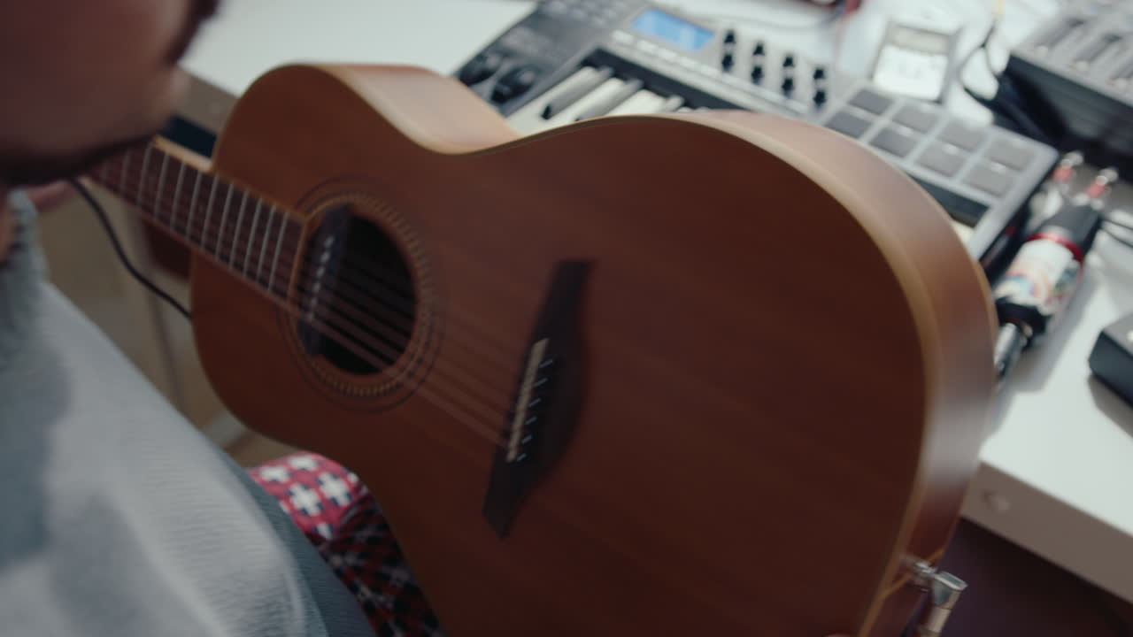 Musician Attaching Cable to Guitar at Home Recording Studio