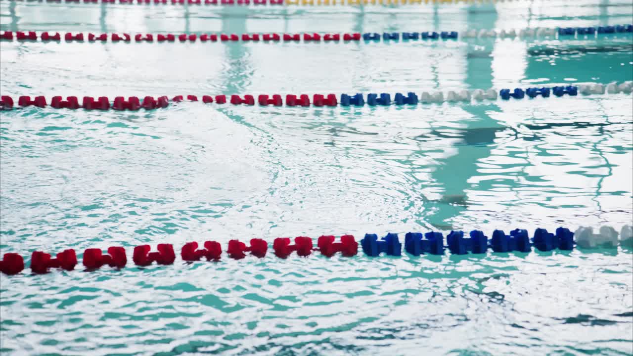 A Competitive Swimmer Preparing to Dive at the Starting Block in a Training Pool, Capturing the Energy and Focus of Aquatic Sports
