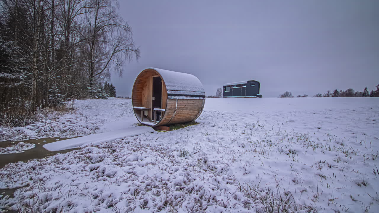 Time-lapse of same nature scene outdoors with wooden cabin and barrel sauna with changing light and colors to reflect different seasons