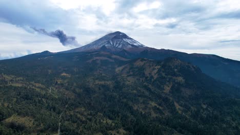 descending drone shot of active volcano in mexico and surrounding forest