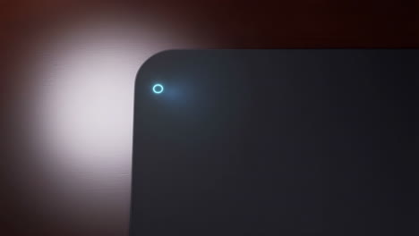 glowing blue indicator light on a modern dark electronic device
