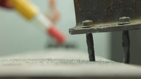 detalle metálico conectado a la viga con viejos tornillos en el taller