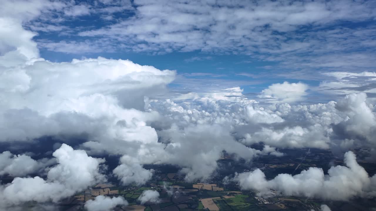 An immersive pilot’s view from an airplane cockpit while flying peacefully through a blue sky full of cottony storm clouds. Ultra-realistic 4K shot