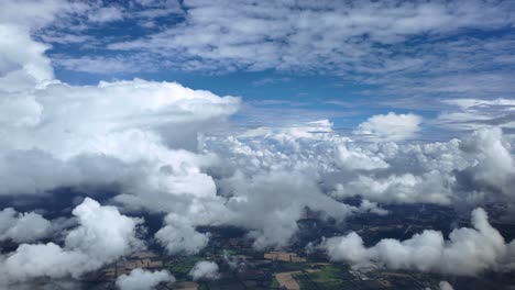 an immersive pilot’s view from an airplane cockpit while flying peacefully through a blue sky full of cottony storm clouds. ultra-realistic 4k shot