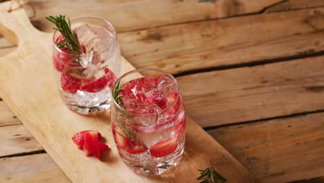 close up of drinks with strawberries on wooden board, with copy space