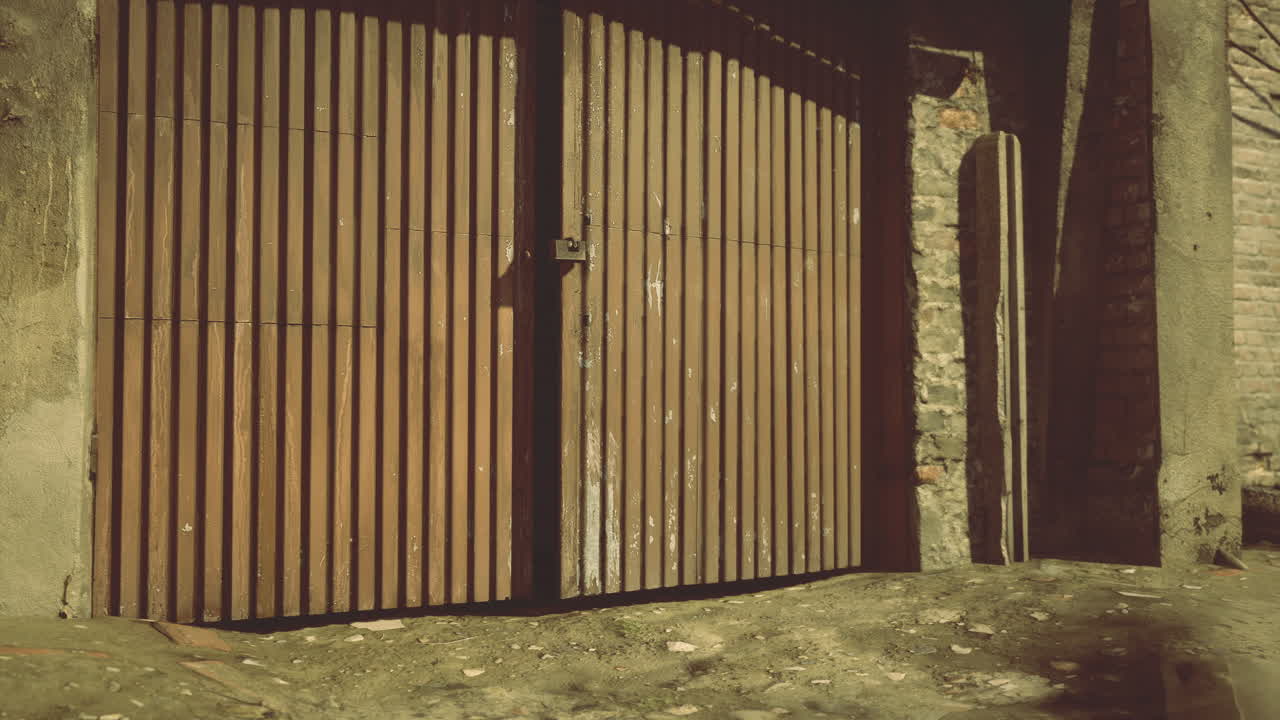 Wooden gate against a textured stone wall in a rustic setting