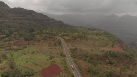 Flying-over-a-red-bus-on-a-hill-road