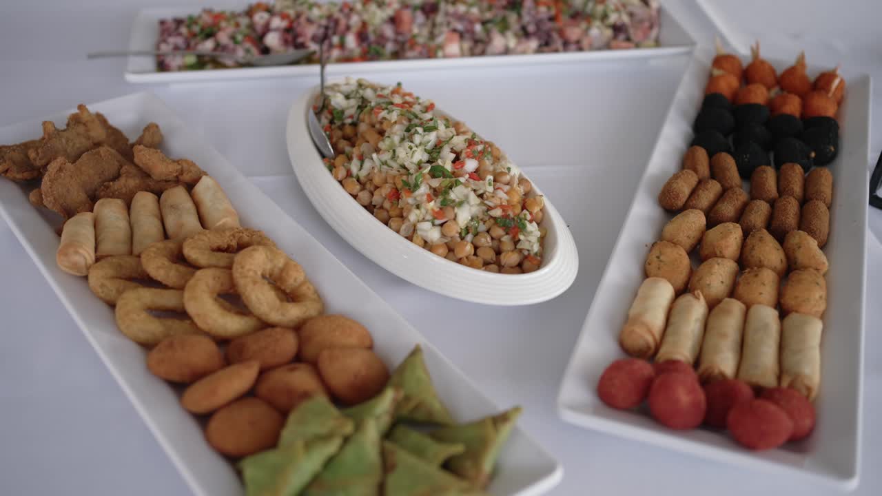 Portuguese style chickpea salad and assorted fried appetizers served on platters at a festive meal
