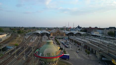 aerial view of a modern train station with connecting tracks leading to suburbs and the city center. beautiful aerial view flight fly reverse drone